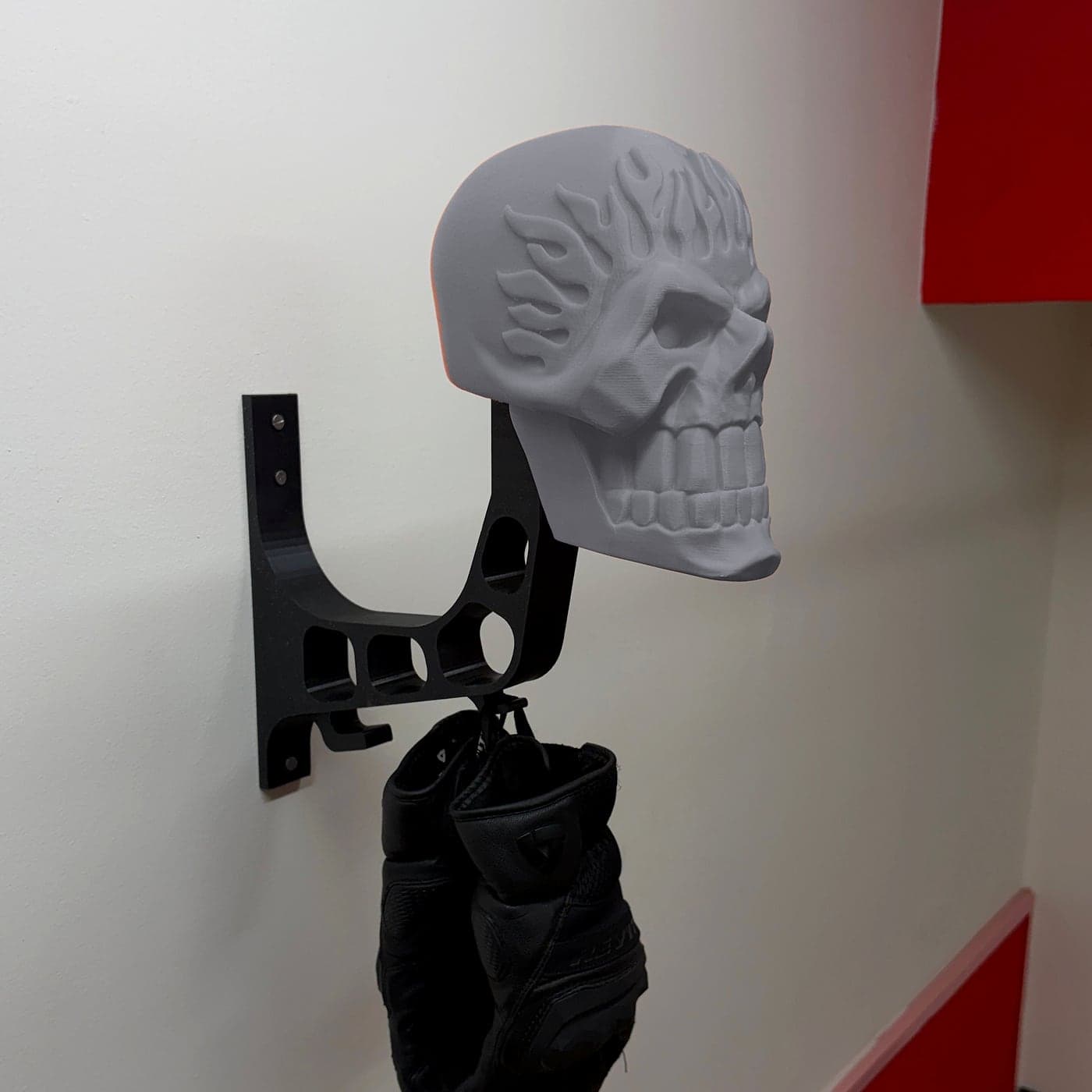 The SKELMET mount in Ghost Grey on its black arm, gloves hanging from the hook