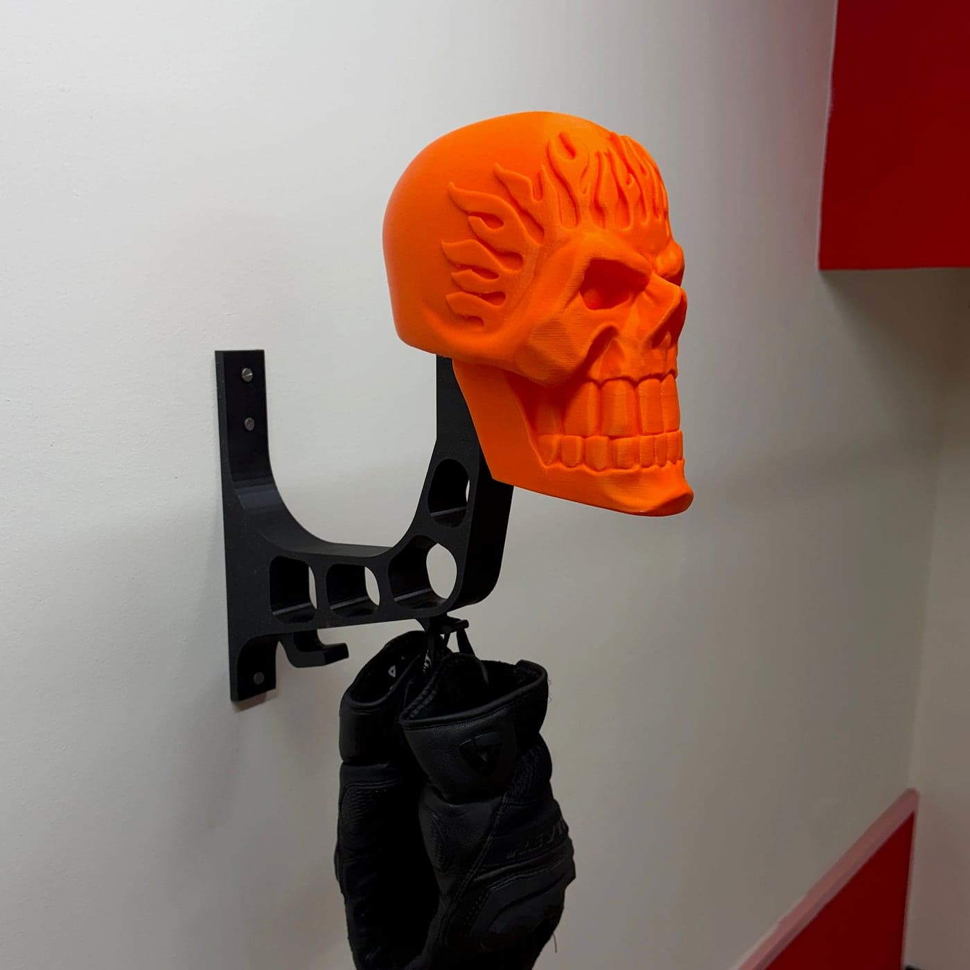 The flame skull on its arm with no helmet, gloves hanging from the hook