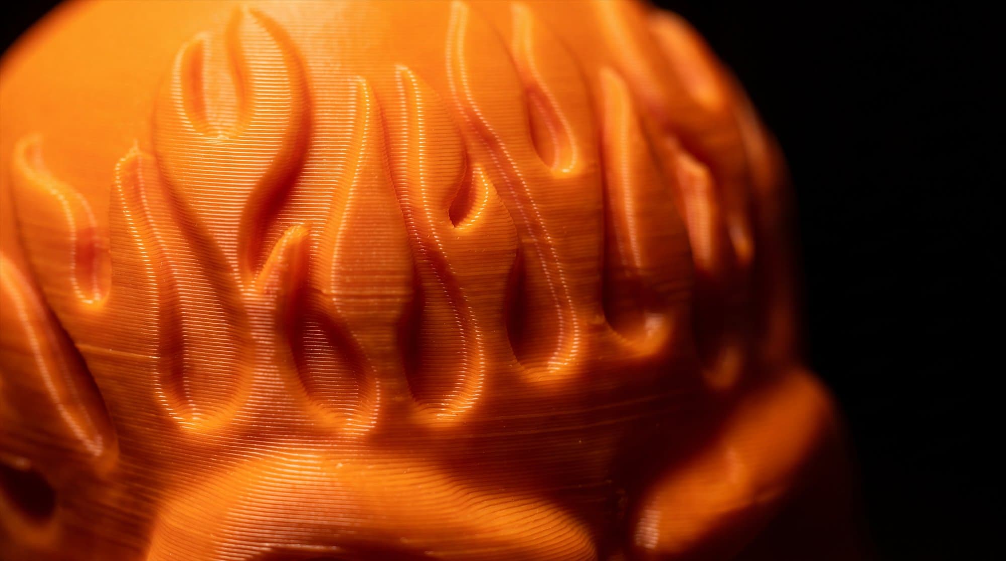 Macro detail of the carved flame relief and 3D-print layer lines